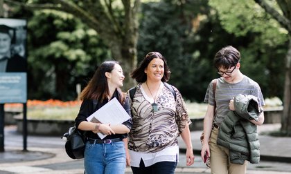 Three students walking on campus
