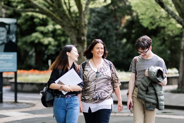 Three students walking on campus