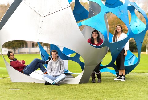 Massey University students standing around sculpture in Palmerston North