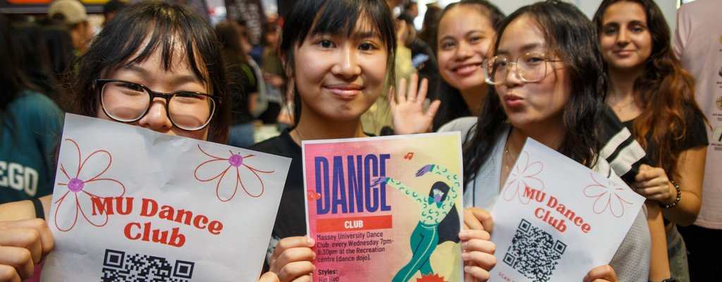 Clubs day at Orientation in Palmerston North. Three students holding flyers about clubs on campus.