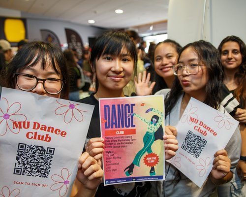 Clubs day at Orientation in Palmerston North. Three students holding flyers about clubs on campus.