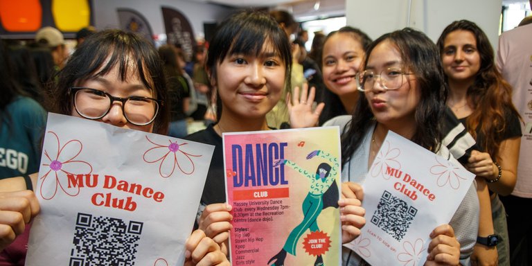 Clubs day at Orientation in Palmerston North. Three students holding flyers about clubs on campus.