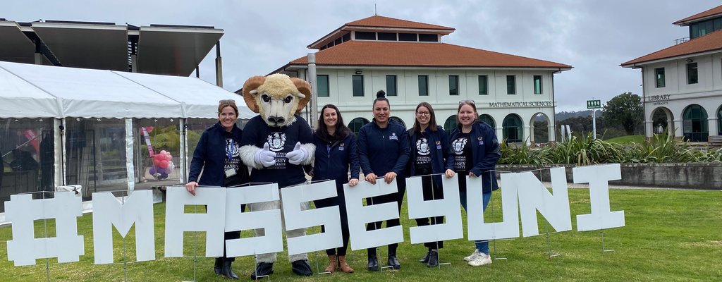 Open Day in Auckland 2024 - The events team and Fergus with MasseyUni sign