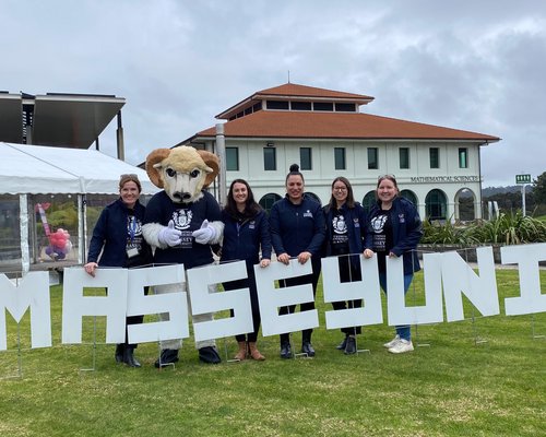 Open Day in Auckland 2024 - The events team and Fergus with MasseyUni sign