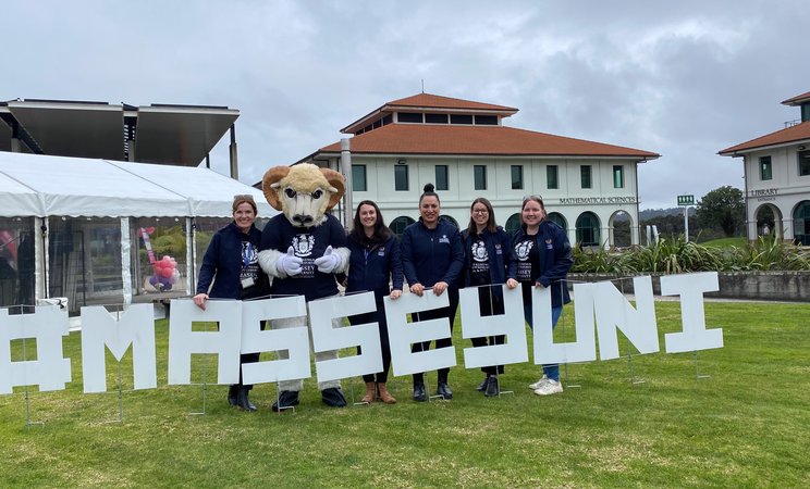 Open Day in Auckland 2024 - The events team and Fergus with MasseyUni sign