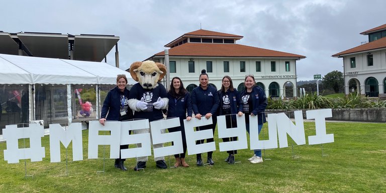 Open Day in Auckland 2024 - The events team and Fergus with MasseyUni sign