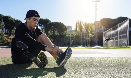 Athlete with a prosthetic leg prepares for training at Massey athletics track