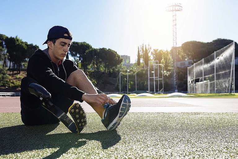 Athlete with a prosthetic leg prepares for training at Massey athletics track